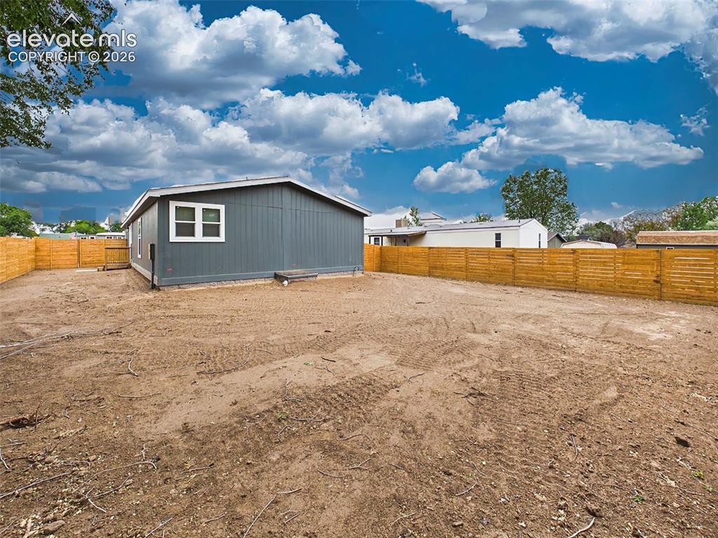 Image 49 of 50: Backyard – Wide view of the fully fenced yard highlights the generous lot s