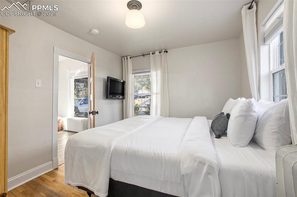 Image 13 of 38: Bedroom with wood finished floors and baseboards