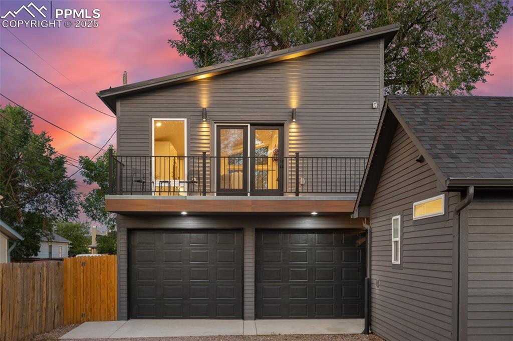 Image 18 of 38: View of front of property featuring a balcony, a garage, and driveway