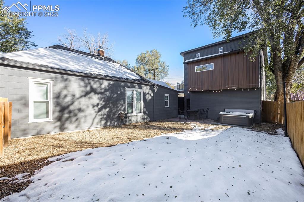 Image 36 of 38: Rear view of property featuring a hot tub, a fenced backyard, a patio area,