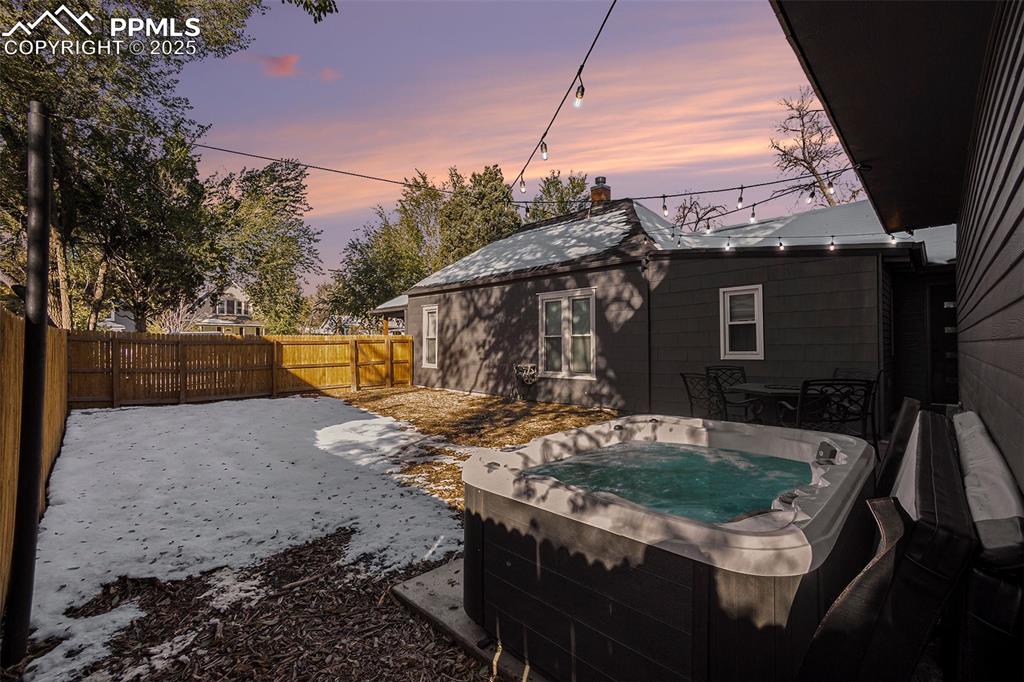 Image 37 of 38: Yard at dusk featuring a hot tub, a patio, and a fenced backyard