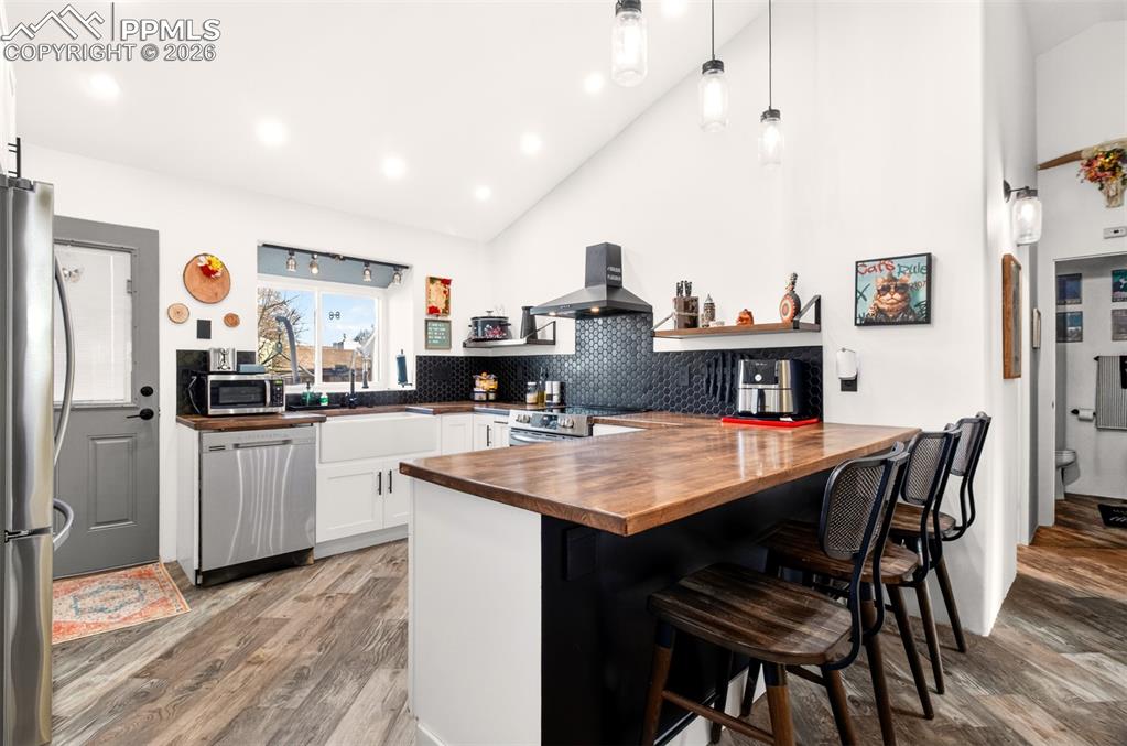 Image 6 of 17: Stylish lvp flooring, new cabinets, wood countertops, farmhouse sink and up