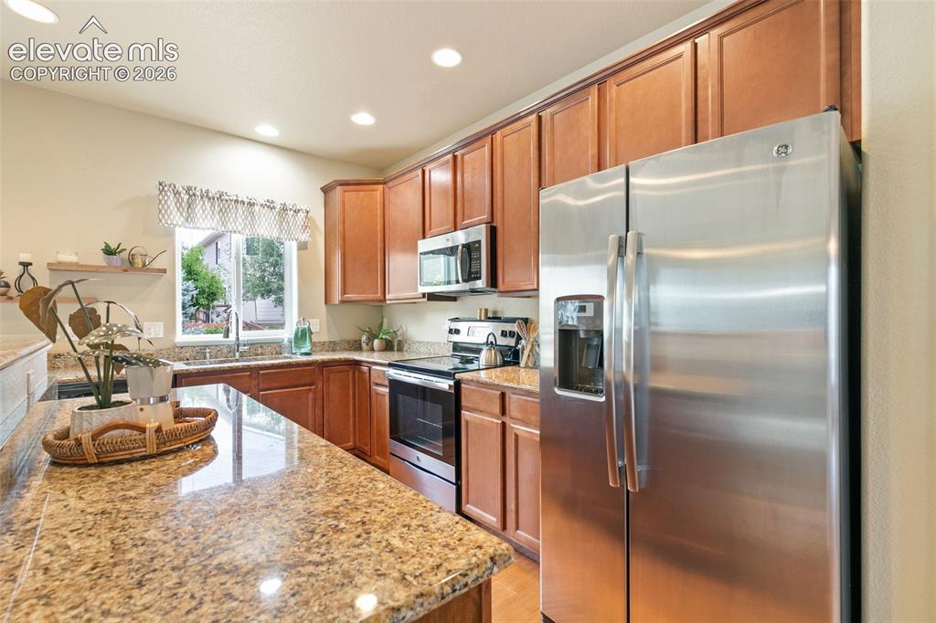 Image 11 of 27: Kitchen featuring stainless appliances and granite countertops