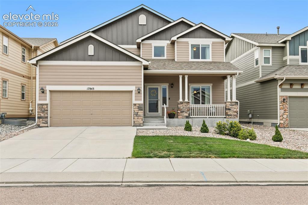 Image 2 of 27: Front of home, with low maintenace landscaping a welcoming front porch