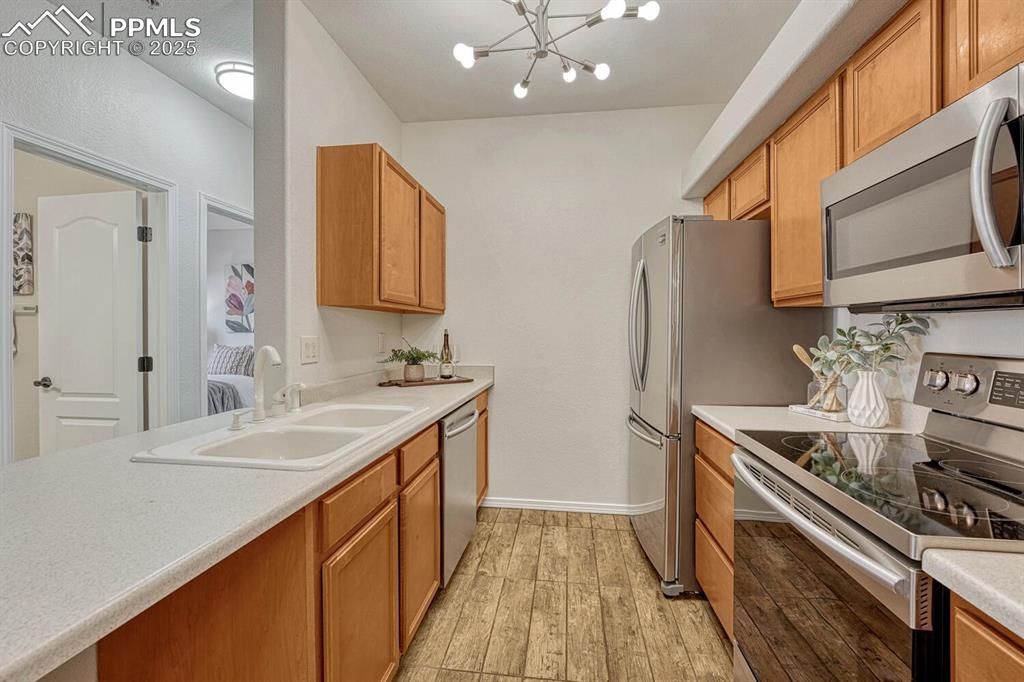 Image 16 of 27: Kitchen with appliances with stainless steel finishes, light countertops, a