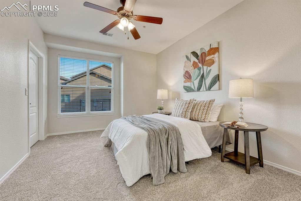 Image 8 of 27: Bedroom featuring new carpet, a ceiling fan and walk-in closet