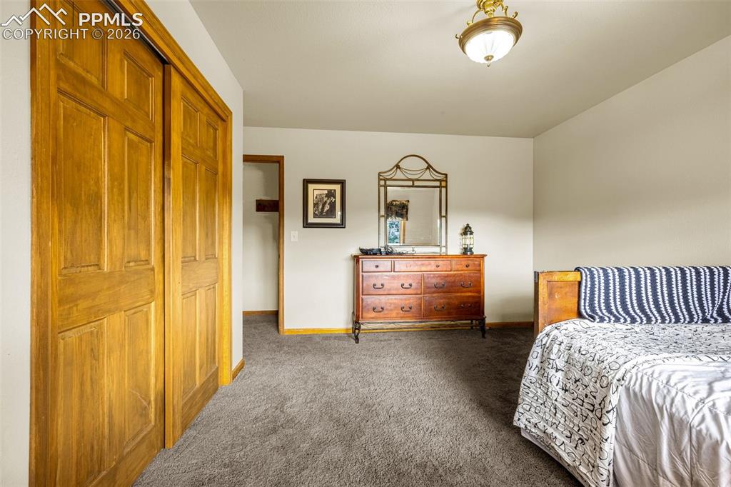 Image 18 of 36: Bedroom 3 with dark carpet and a closet