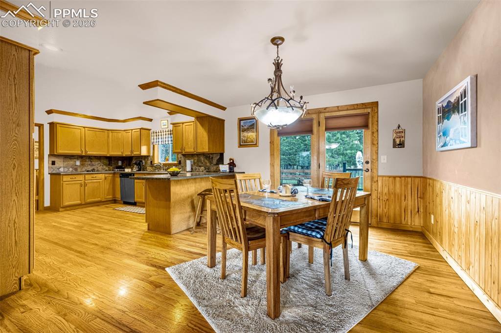 Image 8 of 36: Dining space with glass door opening to deck
