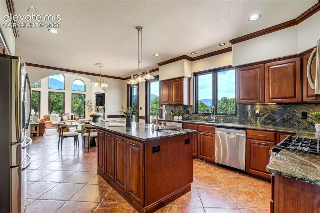 Image 15 of 50: Island with a prep sink & stone counters inspired by the scenery.