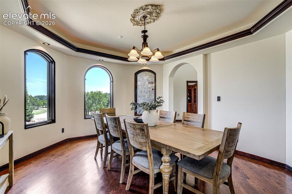 Image 20 of 50: Formal dining space with arched windows & trace ceilings.