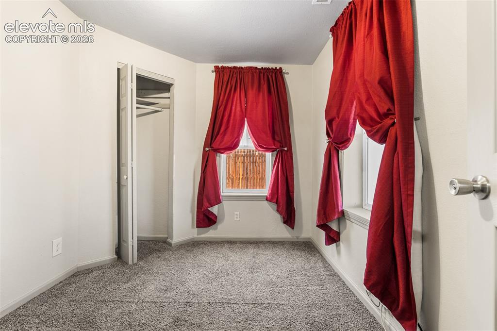 Image 15 of 23: Neutral wall paint, two windows, gray carpet flooring, bi-fold closet door,