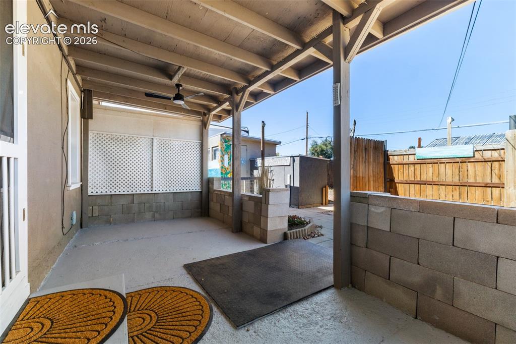 Image 17 of 23: Covered patio with a wood beam ceiling and a built-in ceiling fan