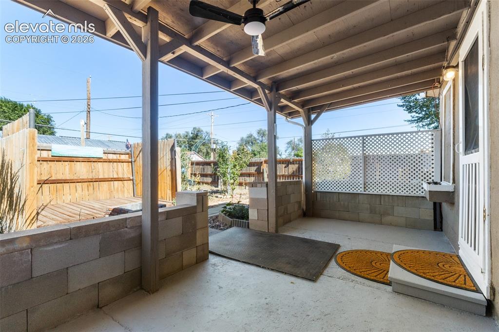 Image 18 of 23: Covered patio featuring a ceiling fan, concrete flooring, and an adjacent w