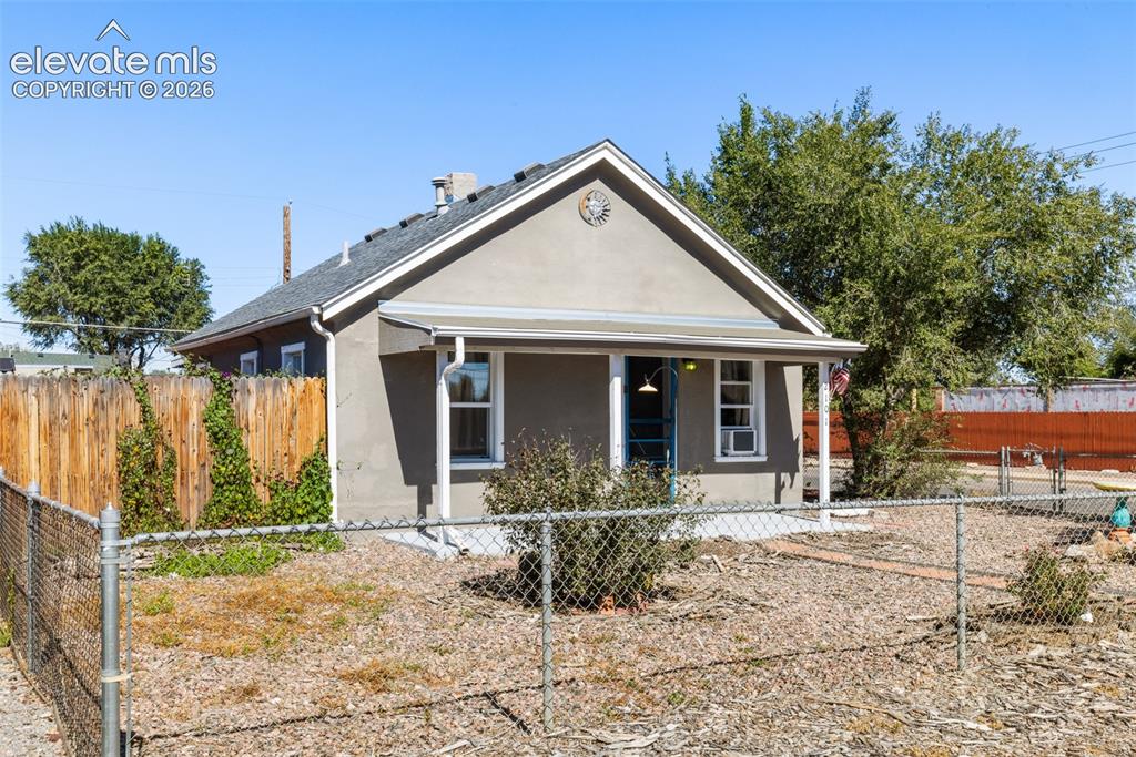 Image 3 of 23: Stucco exterior with a pitched roof, front porch with an awning, and a chai