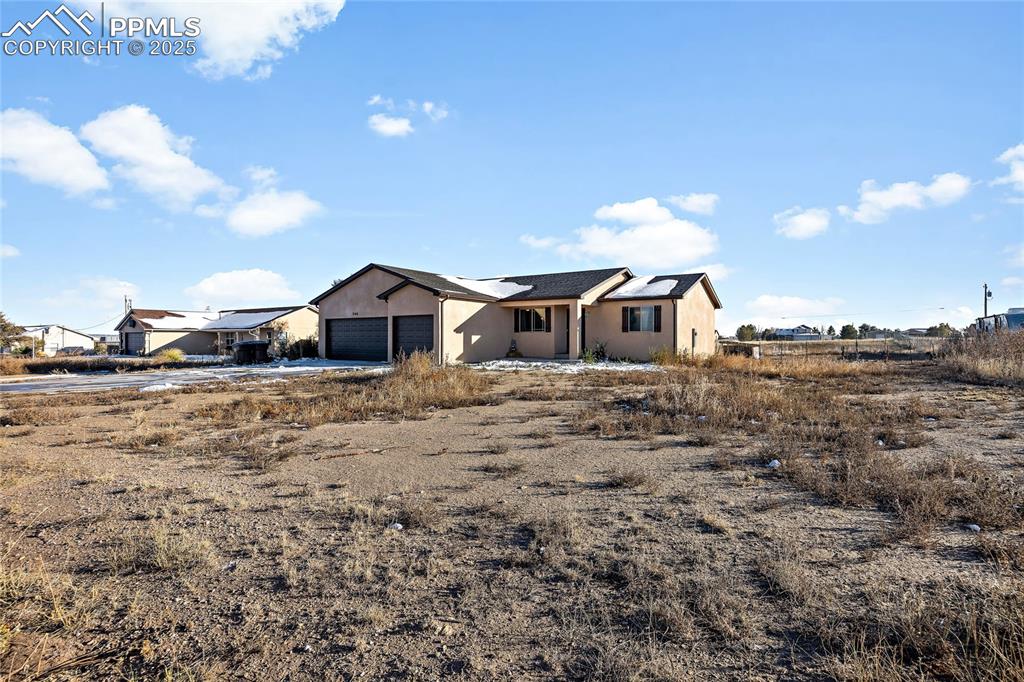Image 2 of 36: View of front of house featuring stucco siding and an attached garage