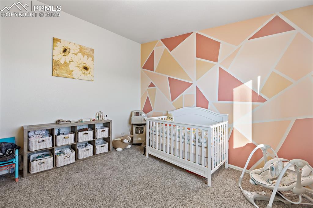 Image 24 of 36: Carpeted bedroom featuring a nursery area
