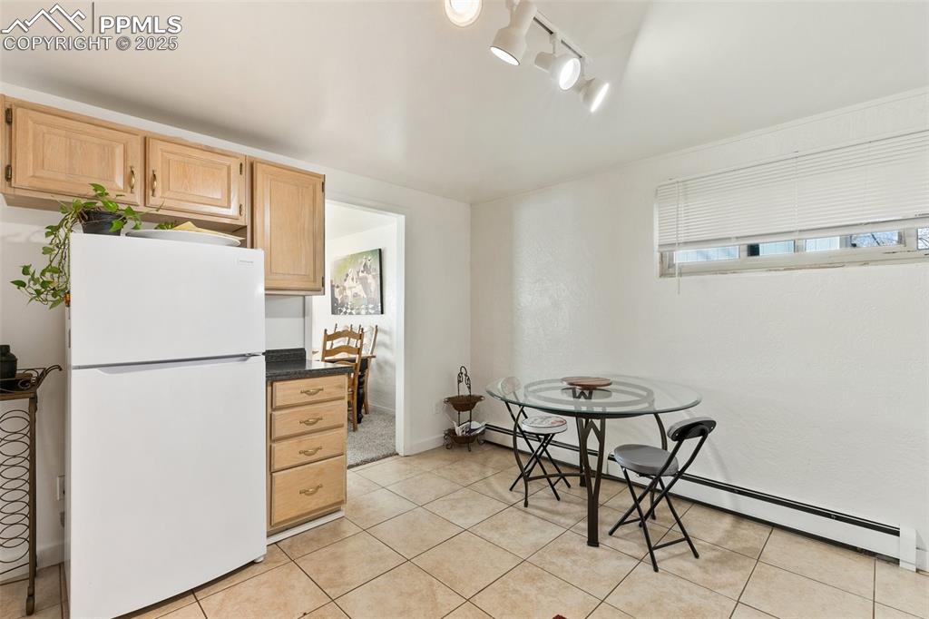 Image 10 of 49: Dining space featuring light tile patterned flooring, baseboards, and a bas