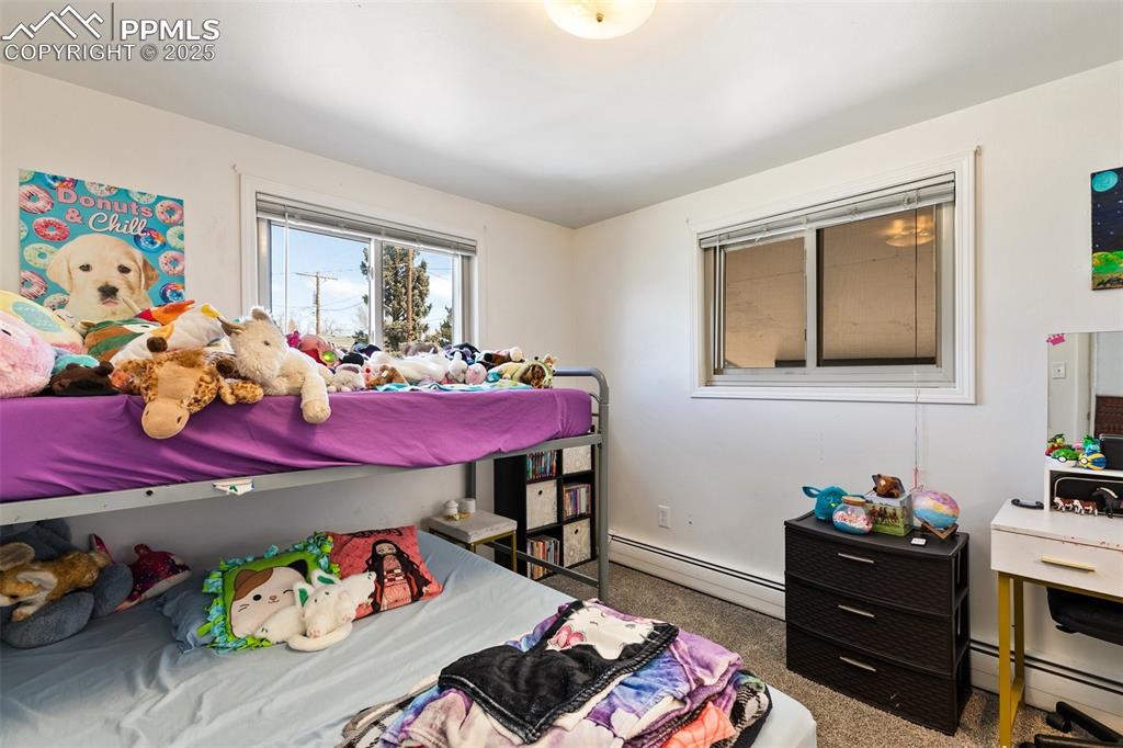 Image 19 of 49: Bedroom featuring baseboard heating and carpet