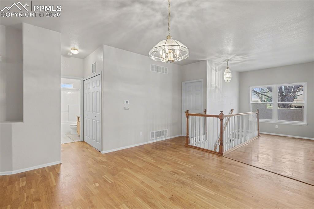 Image 10 of 28: Unfurnished dining area with arched walkways, light wood-style floors, and