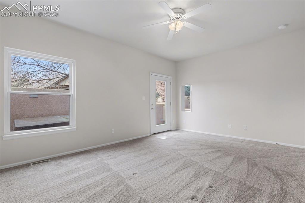 Image 19 of 28: Unfurnished bedroom with light colored carpet, a walk in closet, ceiling fa