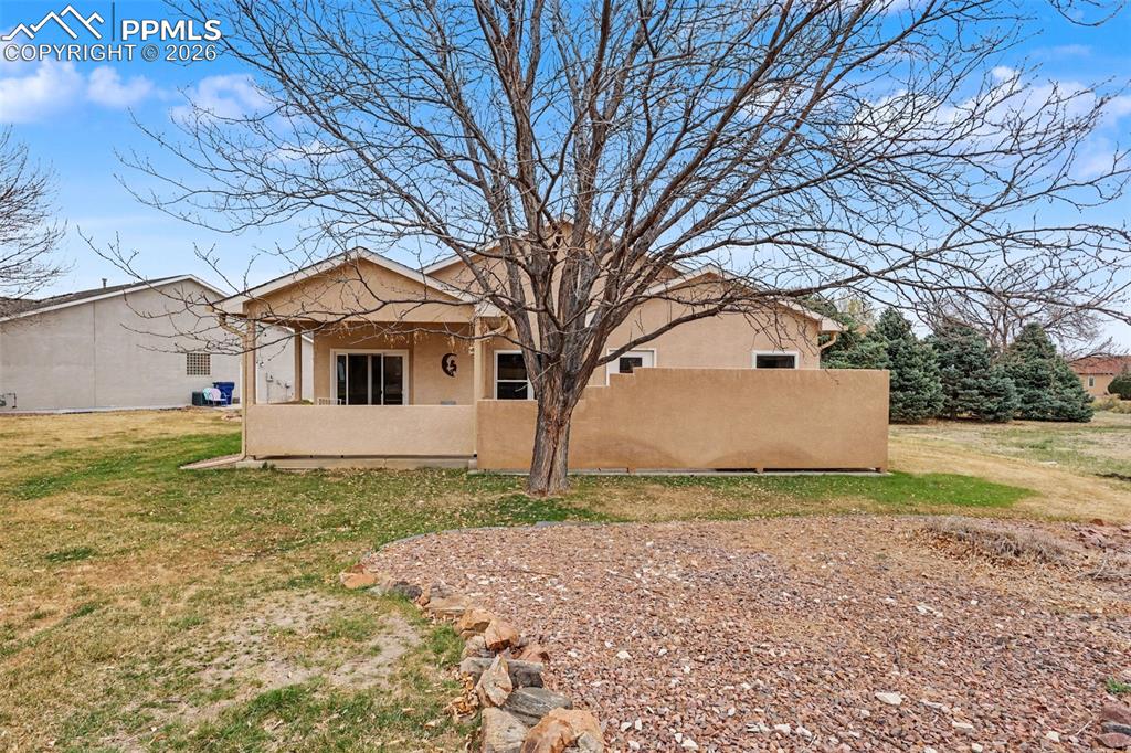 Image 28 of 28: Back of house with stucco siding, a yard, and a patio area