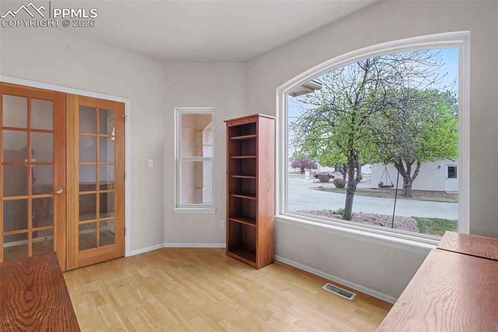 Image 4 of 28: Foyer entrance with french doors and light wood-style floors