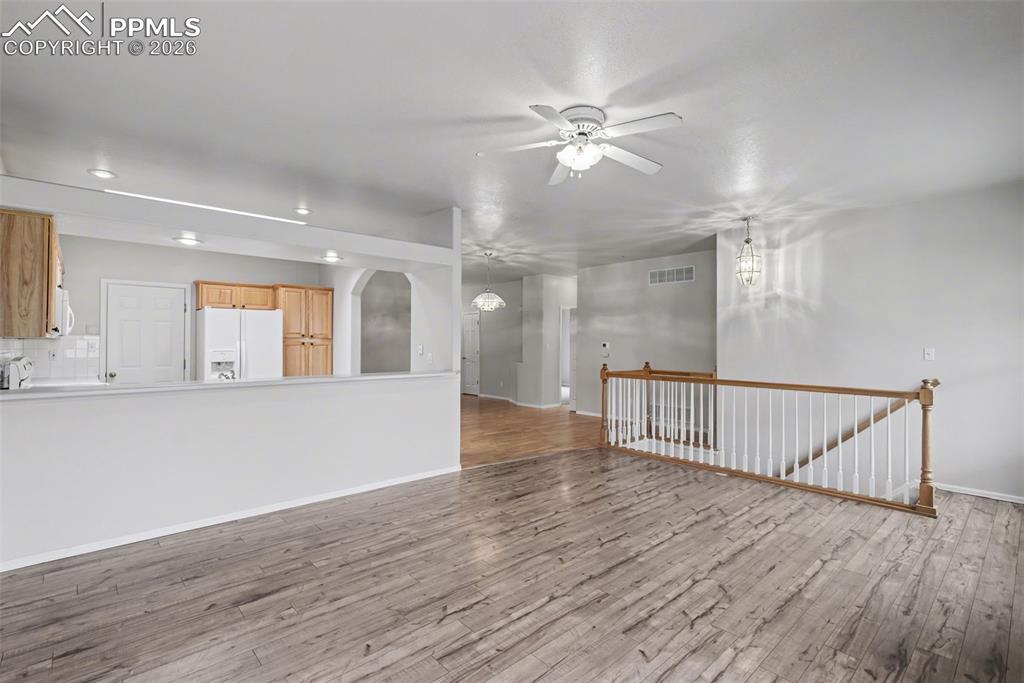 Image 7 of 28: Unfurnished living room with ceiling fan, light wood-style flooring, and a