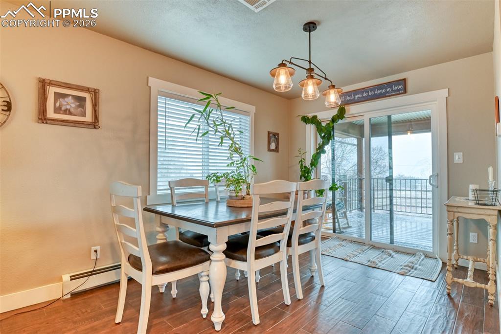 Image 11 of 50: Dining area featuring wood finished floors and a baseboard radiator