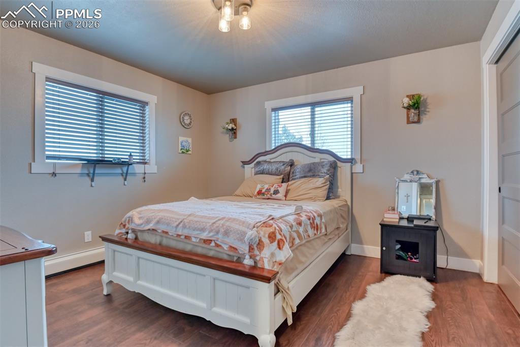Image 21 of 50: Bedroom featuring wood finished floors and baseboard heating