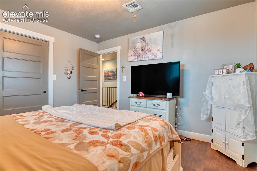 Image 23 of 50: Bedroom with a closet and dark wood finished floors
