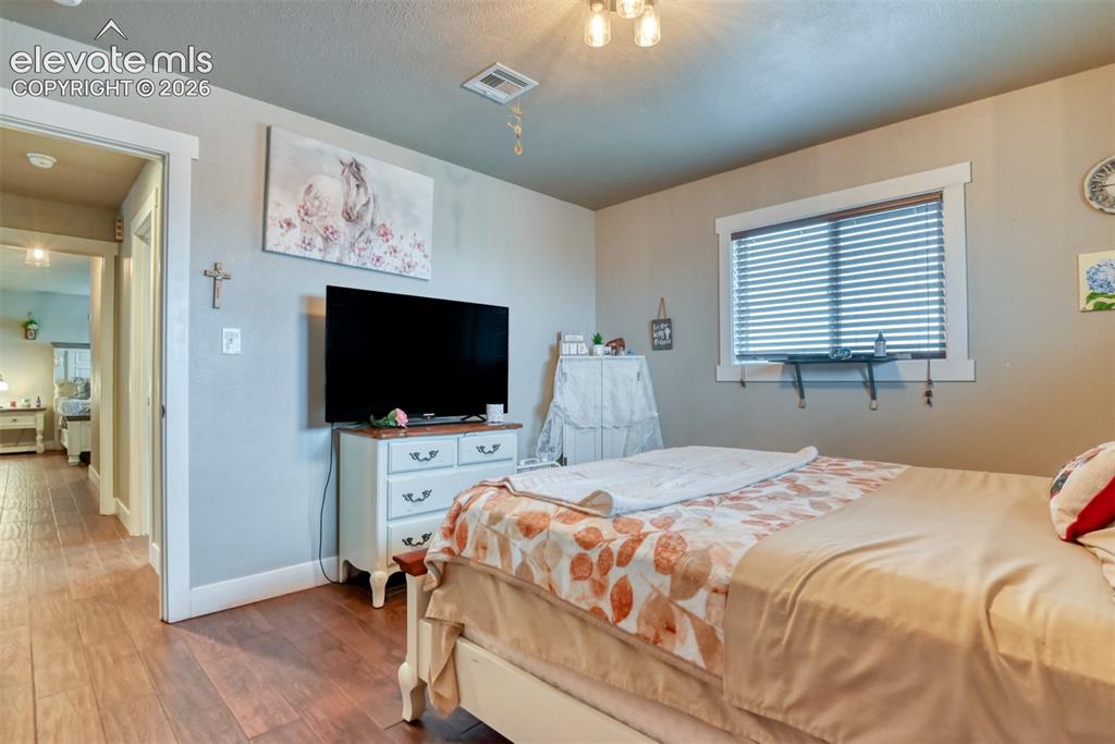 Image 24 of 50: Bedroom with baseboards and wood finished floors