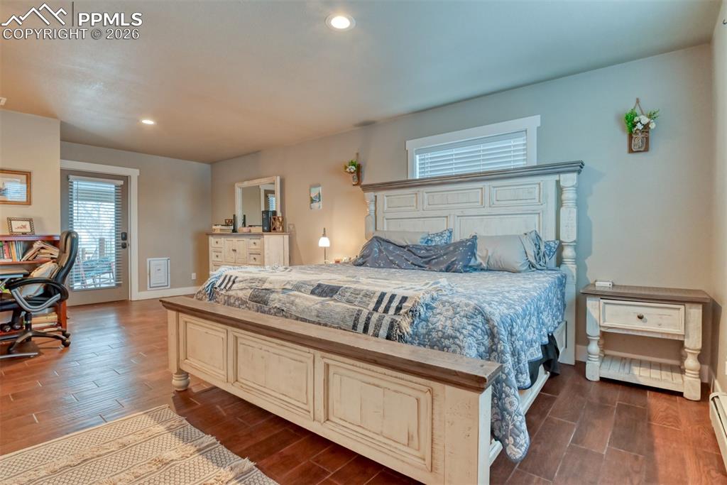 Image 25 of 50: Bedroom featuring wood finish floors, recessed lighting, and access to exte