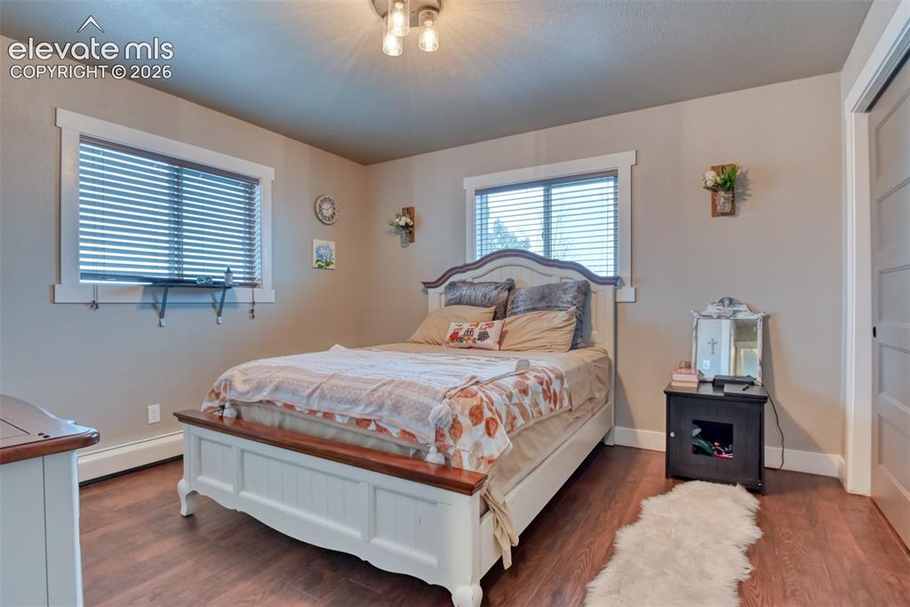 Image 25 of 50: Bedroom featuring wood finished floors and baseboard heating