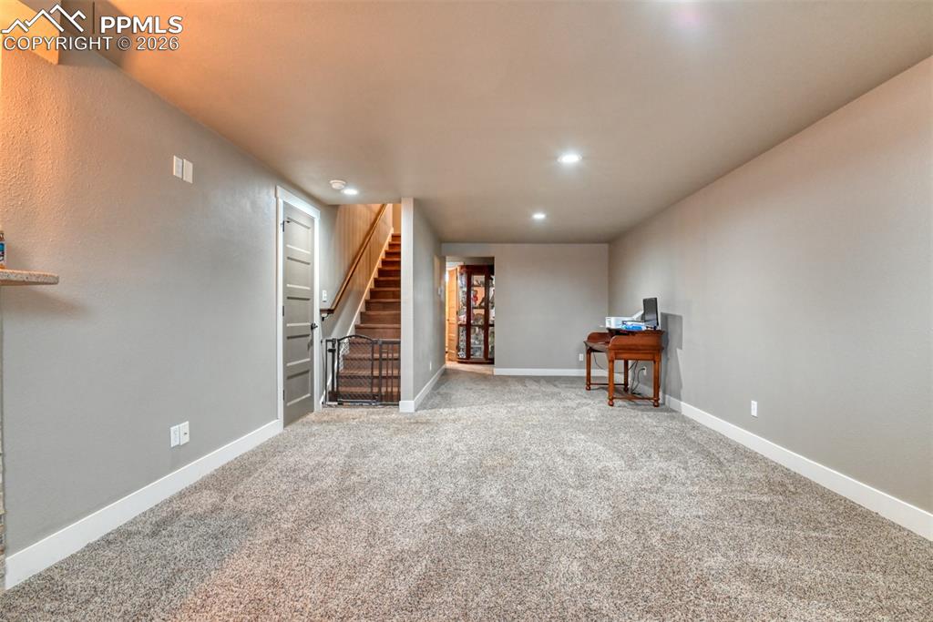 Image 27 of 50: Finished below grade area with light colored carpet and recessed lighting