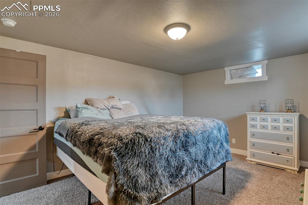 Image 38 of 50: Bedroom featuring light carpet and a textured ceiling