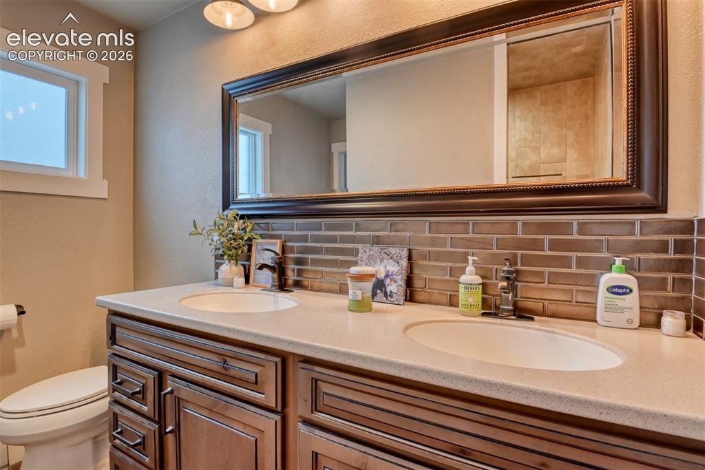 Image 41 of 50: Full bath featuring backsplash, a textured wall, and double vanity