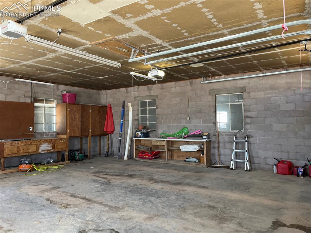 Image 47 of 50: Garage with concrete block wall and a garage door opener