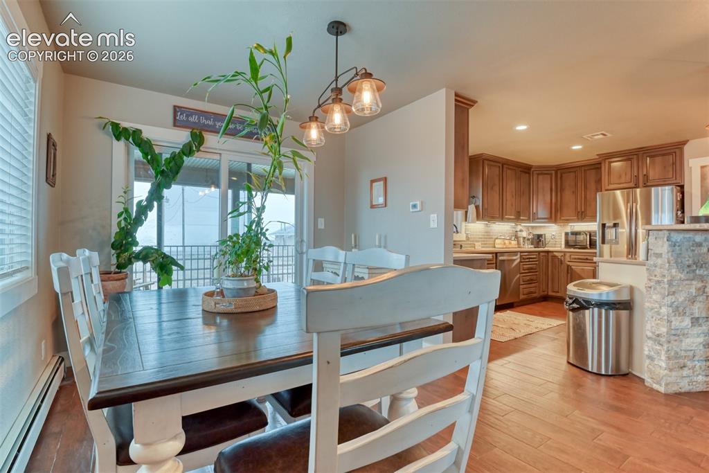 Image 7 of 50: Dining room featuring light wood-style floors, a baseboard radiator, and re
