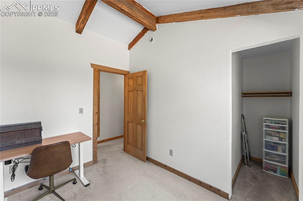 Image 15 of 39: Bedroom with beamed ceiling and closet