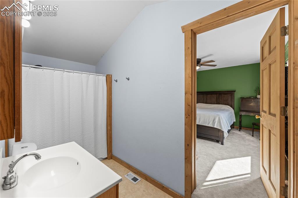 Image 17 of 39: Full bath featuring lofted ceiling, vanity and master bedroom