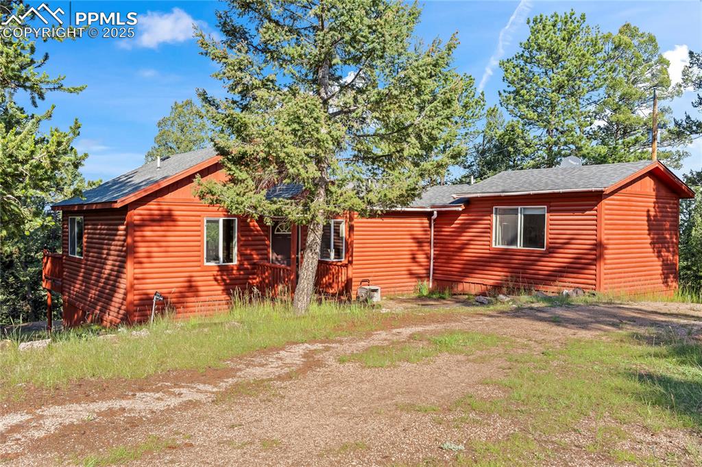 Image 2 of 39: Back of house with log veneer siding and roof with shingles