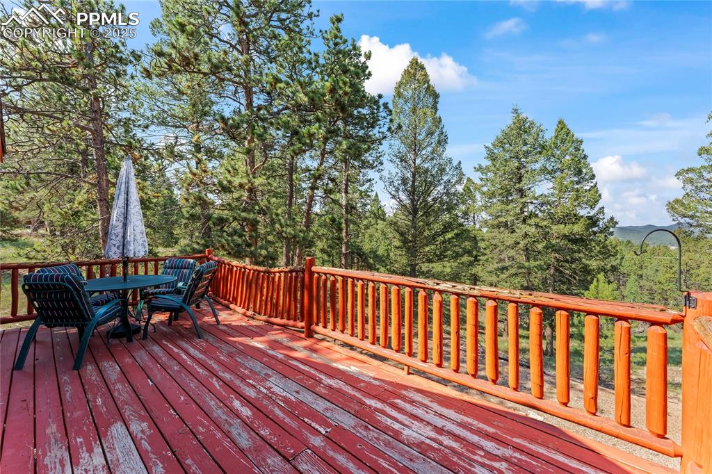 Image 27 of 39: Deck with outdoor dining space. Back railing needs repair.