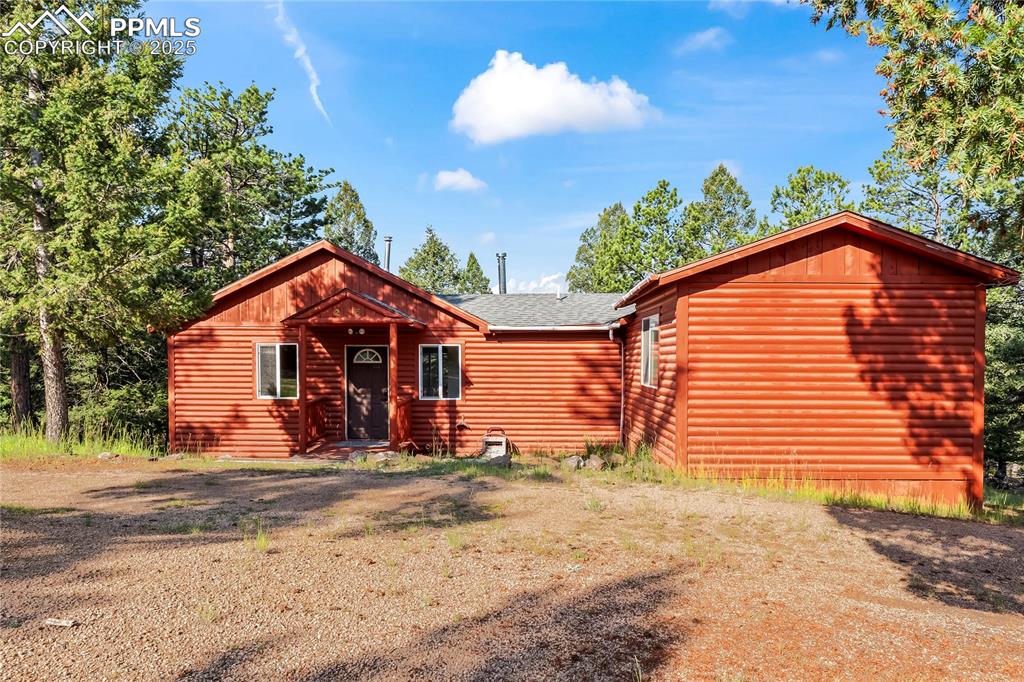 Image 3 of 39: View of front of home with log veneer siding and a shingled roof