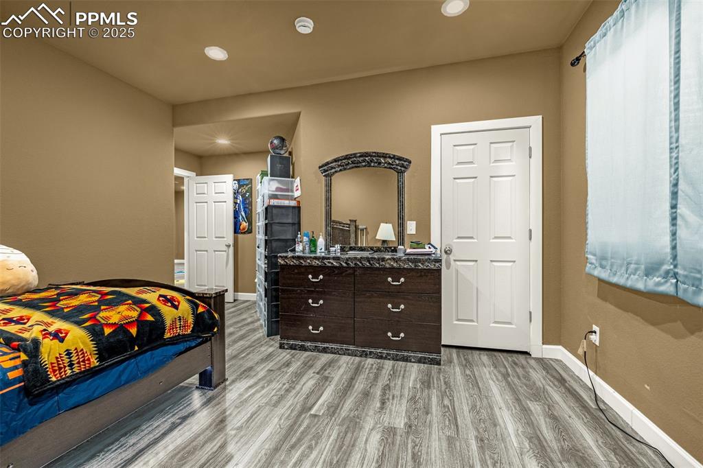 Image 33 of 45: Bedroom with light wood-style flooring and recessed lighting