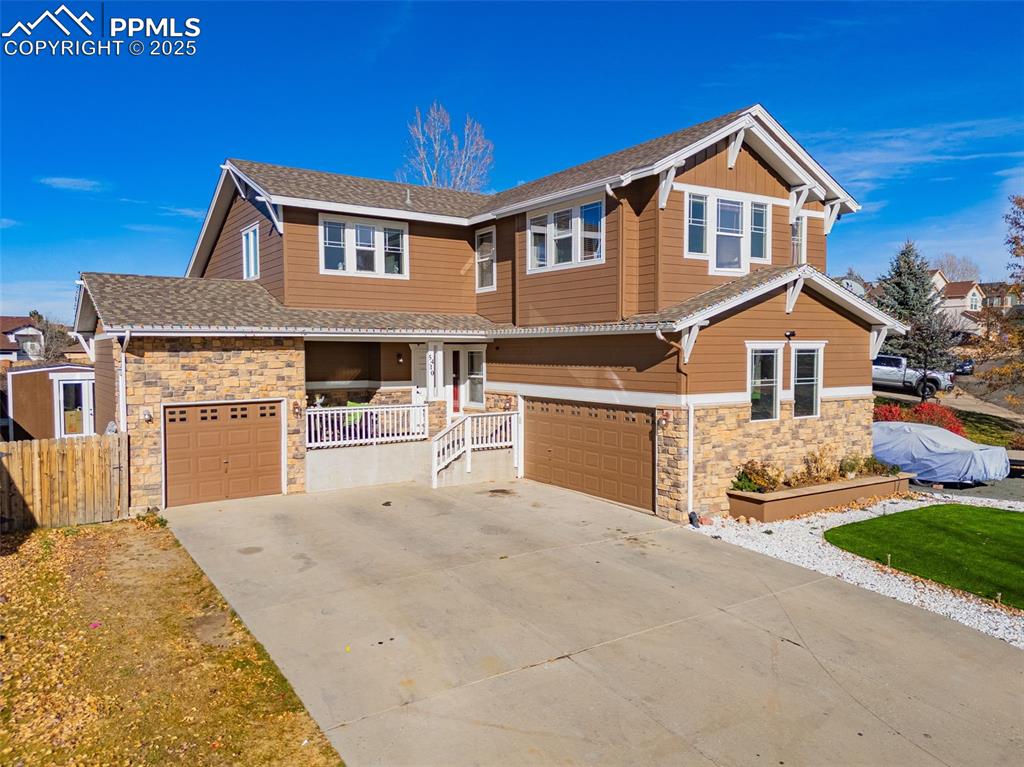 Image 4 of 45: Craftsman inspired home featuring stone siding, driveway, a garage, and a s