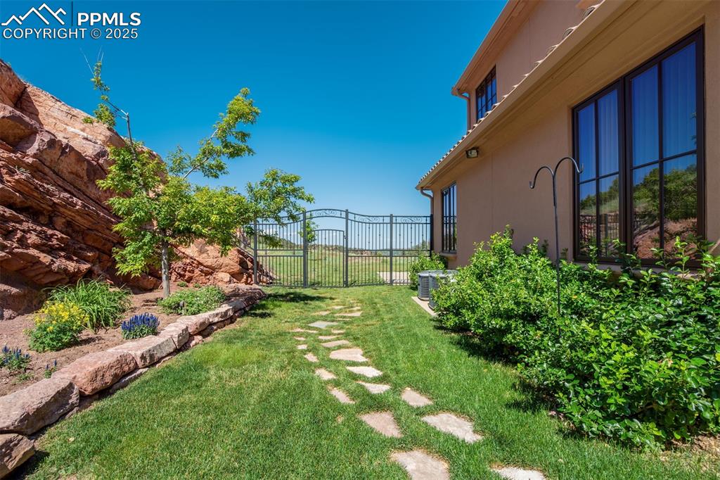 Image 44 of 50: Back yard off of main patio w/ magnificent wrought iron gate!