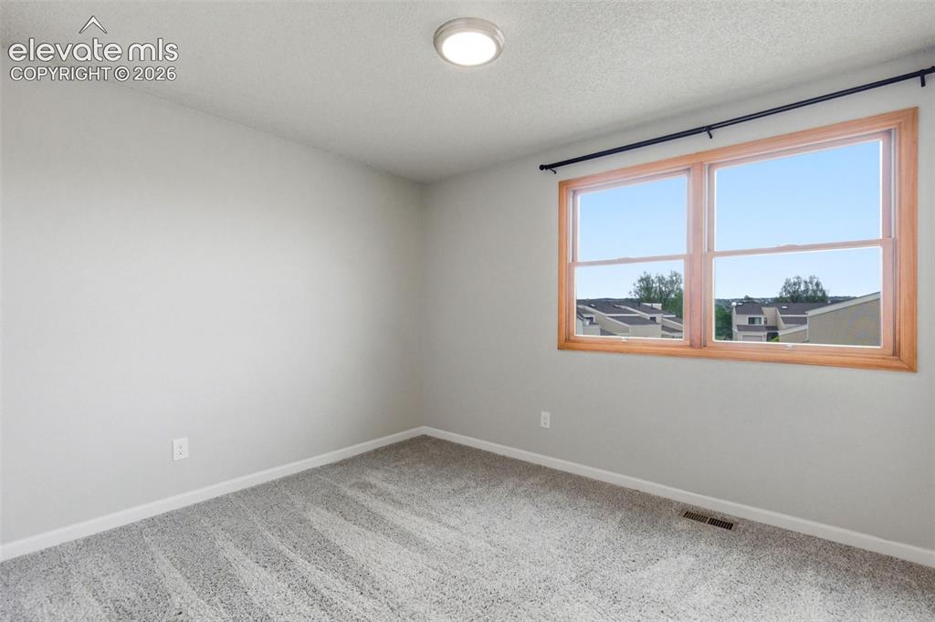 Image 19 of 50: Spacious room with a double window featuring natural wood-finish trim