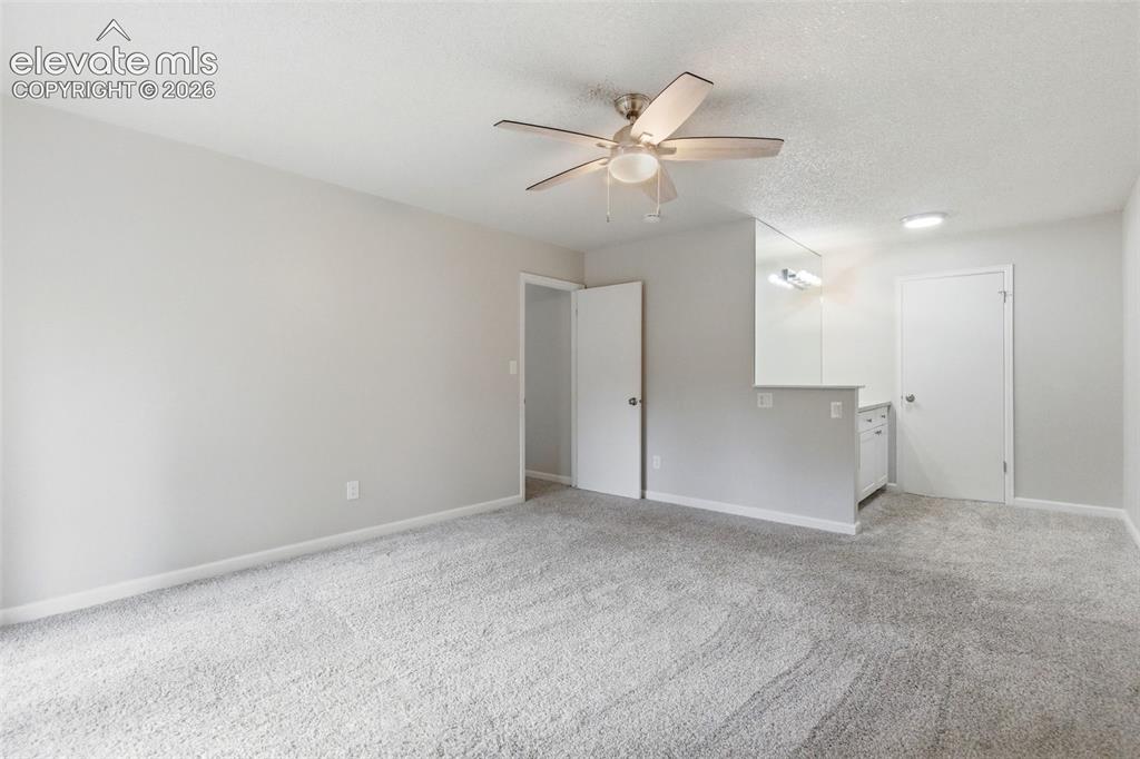 Image 26 of 50: Spacious room featuring light gray walls, textured white ceilings, and neut