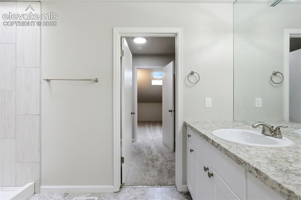 Image 28 of 50: Bathroom vanity featuring a granite countertop, undermount sink, brushed ni