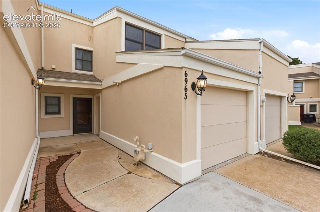 Image 3 of 50: Exterior facade with light-toned stucco and white trim